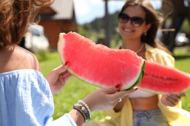 Women with slices of juicy watermelon outdoors