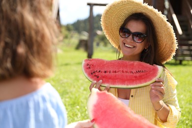 Women with slices of juicy watermelon outdoors