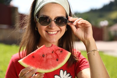 Photo of Happy woman holding slice of juicy watermelon