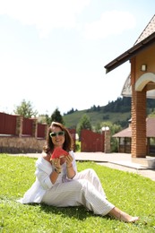 Photo of Happy woman holding slice of juicy watermelon on green grass outdoors