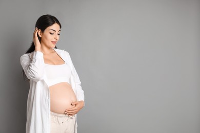 Photo of Portrait of beautiful pregnant woman on grey background, space for text