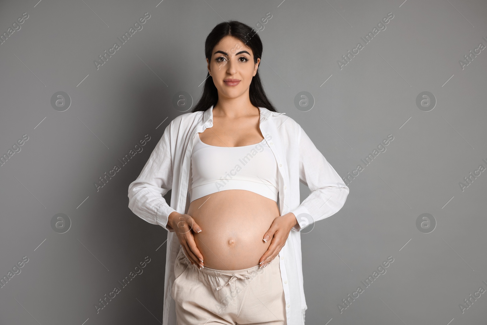 Photo of Portrait of beautiful pregnant woman on grey background