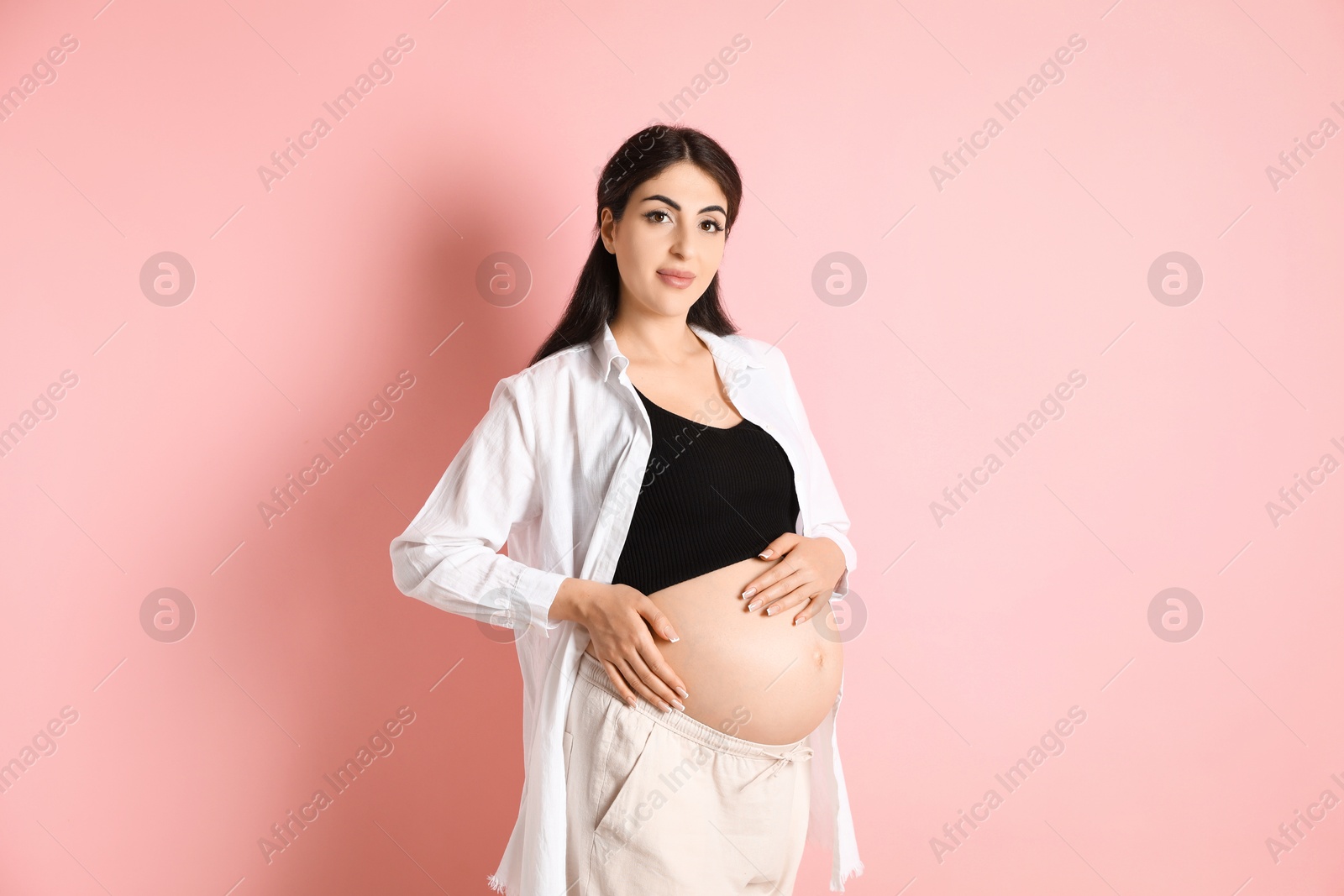 Photo of Portrait of beautiful pregnant woman on pink background