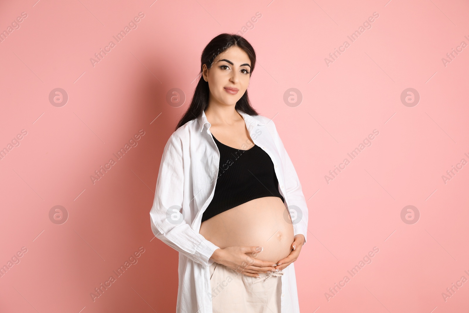 Photo of Portrait of beautiful pregnant woman on pink background