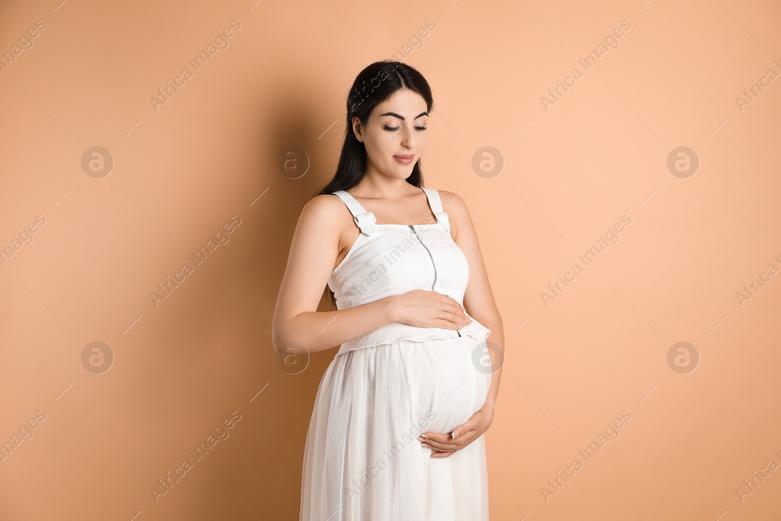 Photo of Portrait of beautiful pregnant woman on beige background