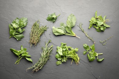 Photo of Different fresh herbs on grey textured table, flat lay