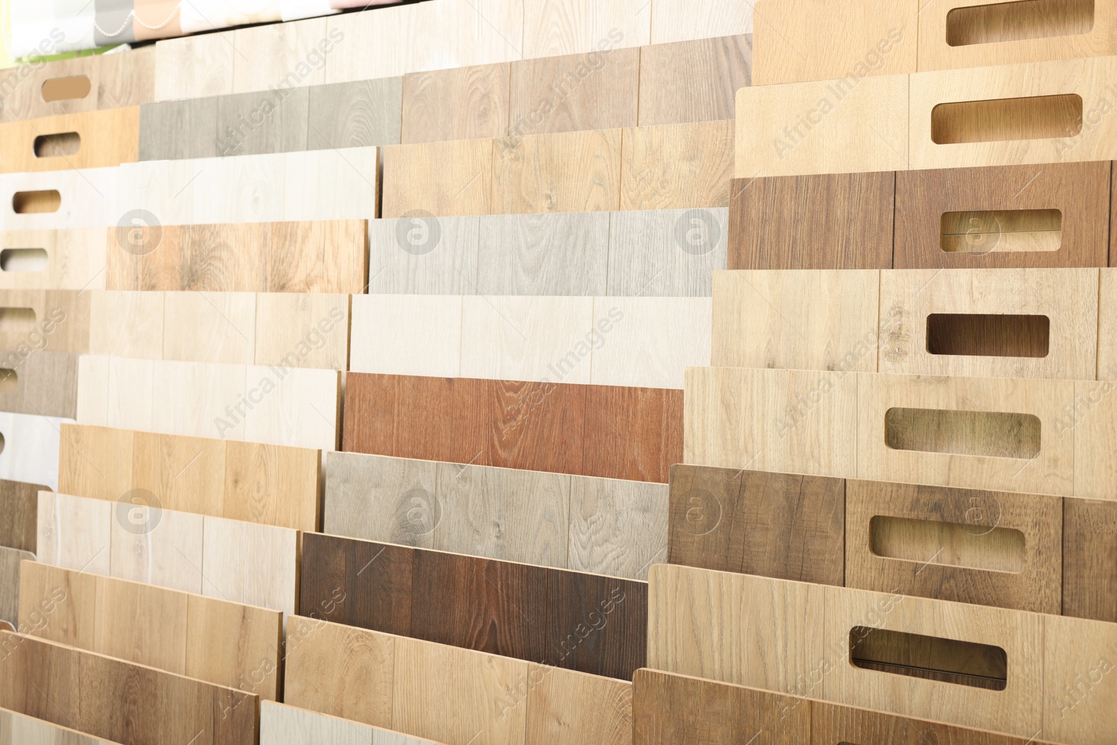 Photo of Many different samples of wooden flooring in store, closeup