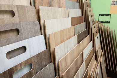 Photo of Many different samples of wooden flooring in store, closeup