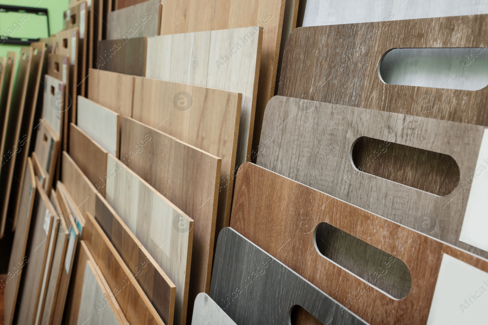 Photo of Many different samples of wooden flooring in store, closeup