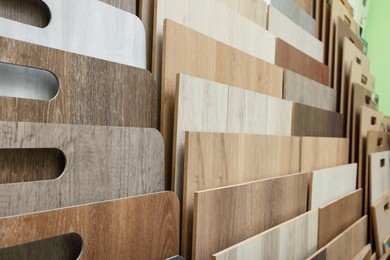 Photo of Many different samples of wooden flooring in store, closeup