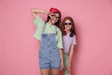 Photo of Happy teenage girls posing on pink background