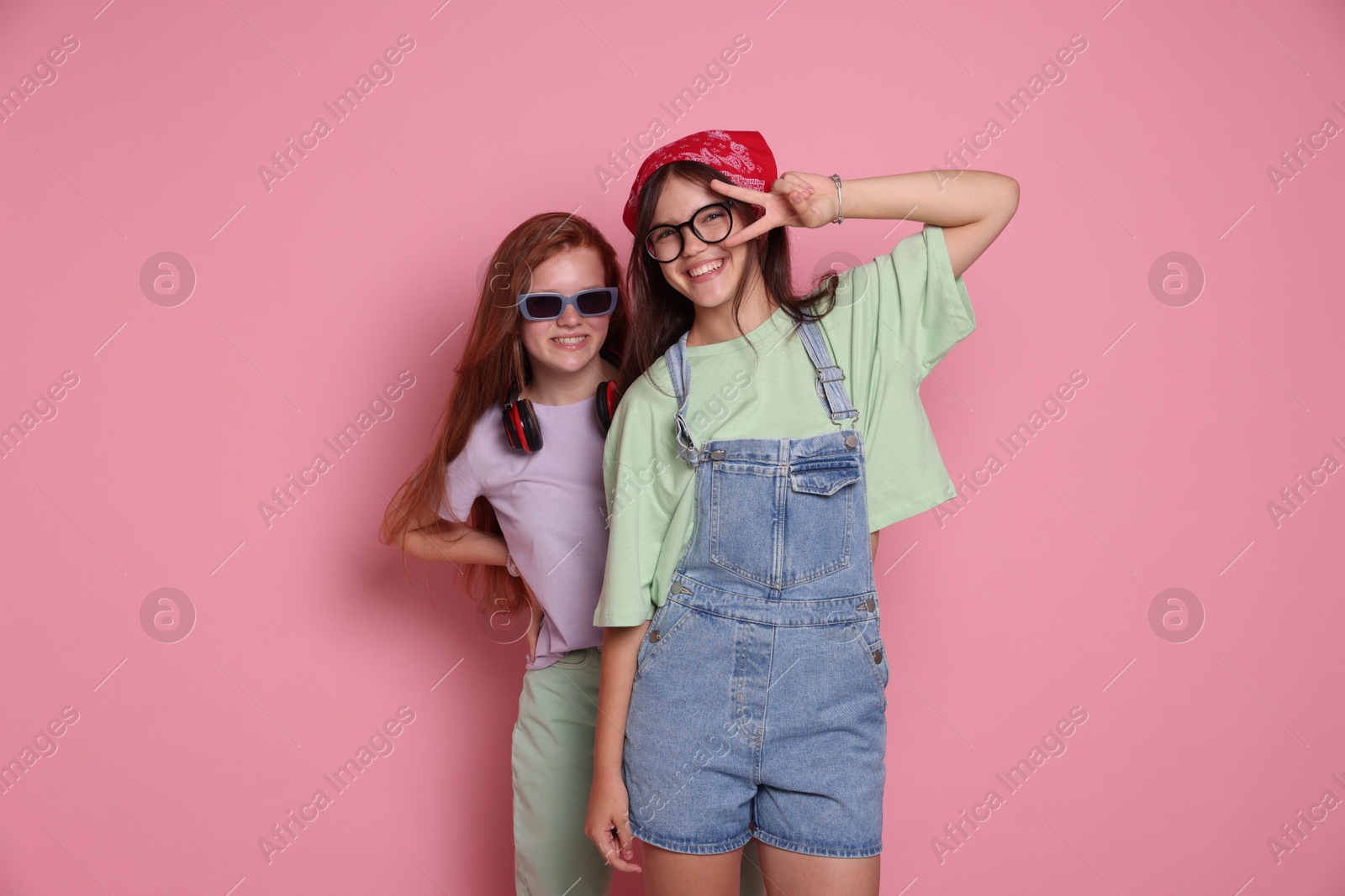 Photo of Happy teenage girls posing on pink background