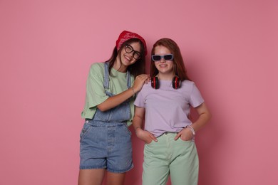 Photo of Happy teenage girls posing on pink background