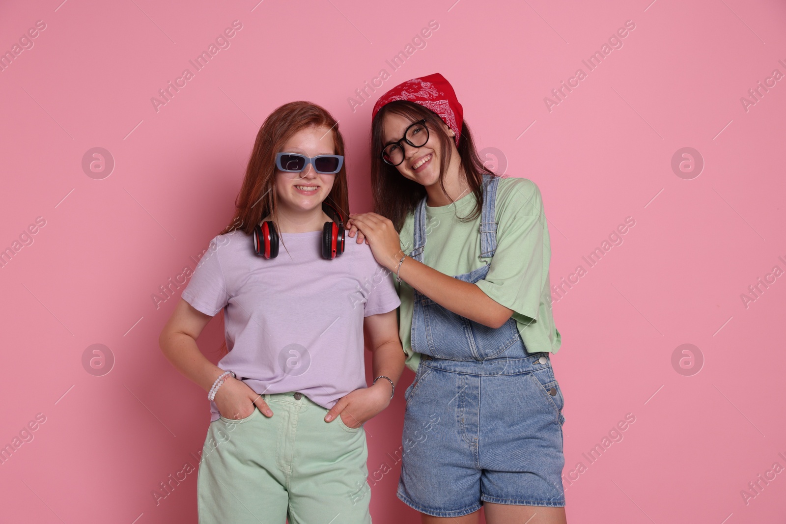 Photo of Happy teenage girls posing on pink background