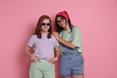 Happy teenage girls posing on pink background