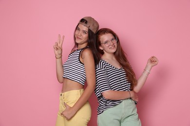 Happy teenage girls posing on pink background