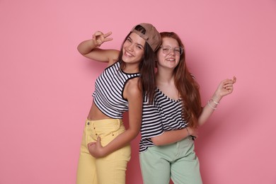 Photo of Happy teenage girls posing on pink background