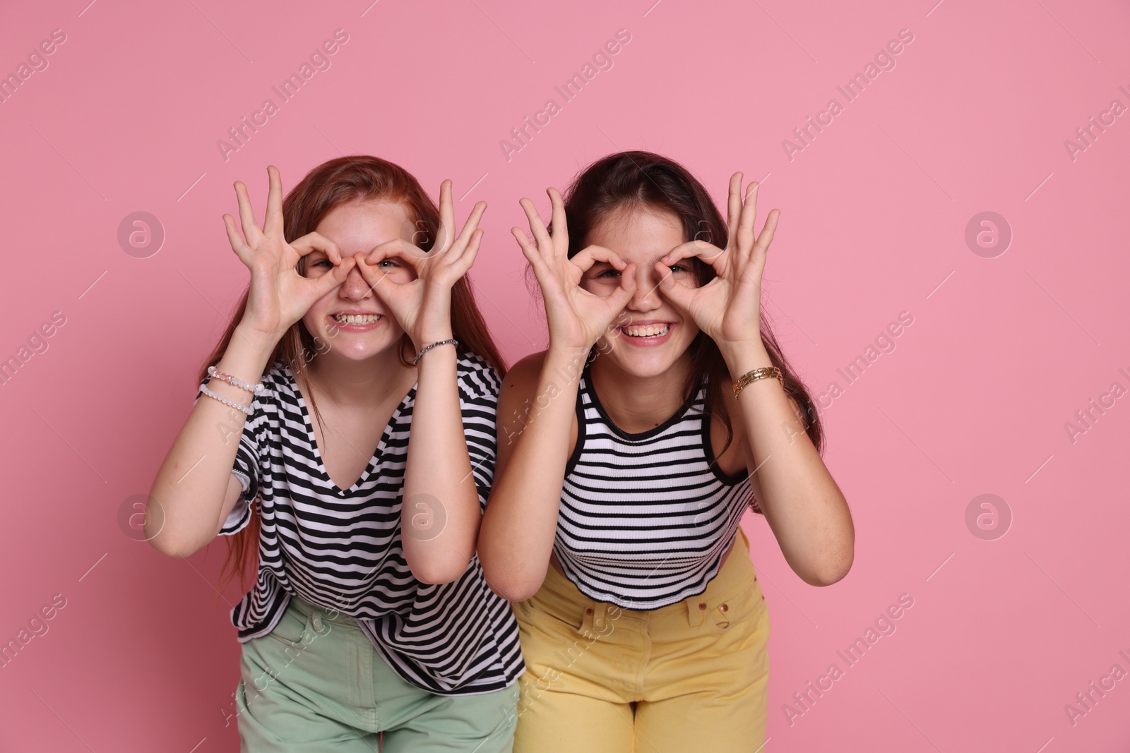 Photo of Happy teenage girls posing on pink background