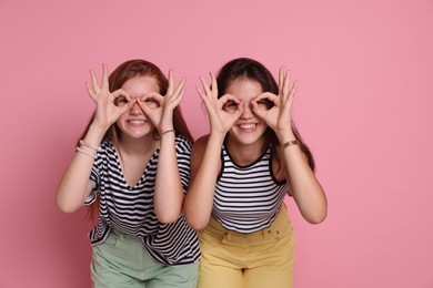 Happy teenage girls posing on pink background