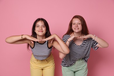 Photo of Happy teenage girls posing on pink background