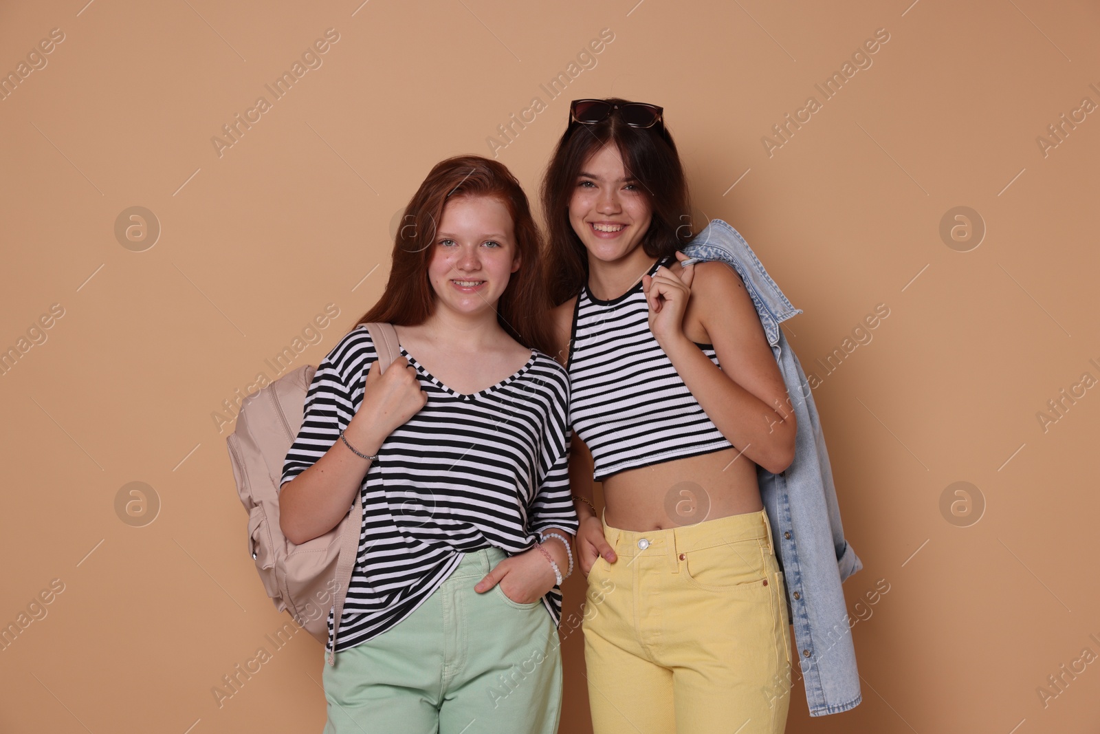 Photo of Happy teenage girls posing on beige background