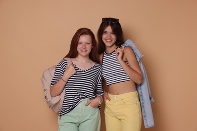 Happy teenage girls posing on beige background