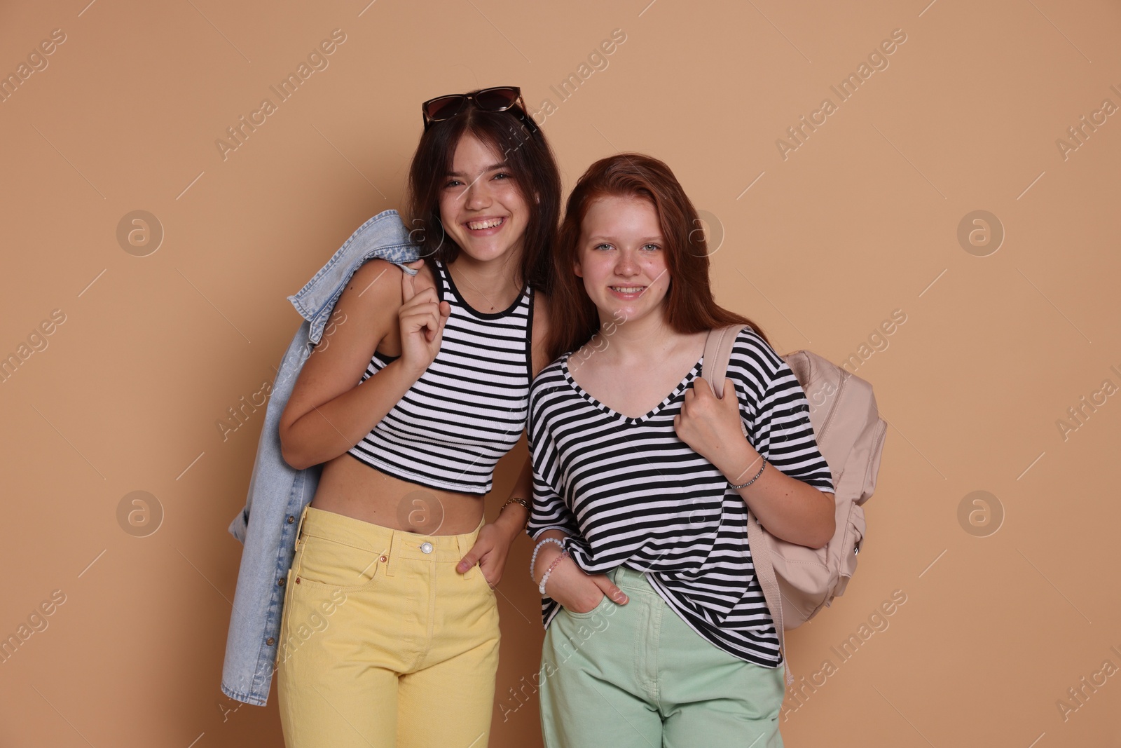 Photo of Happy teenage girls posing on beige background