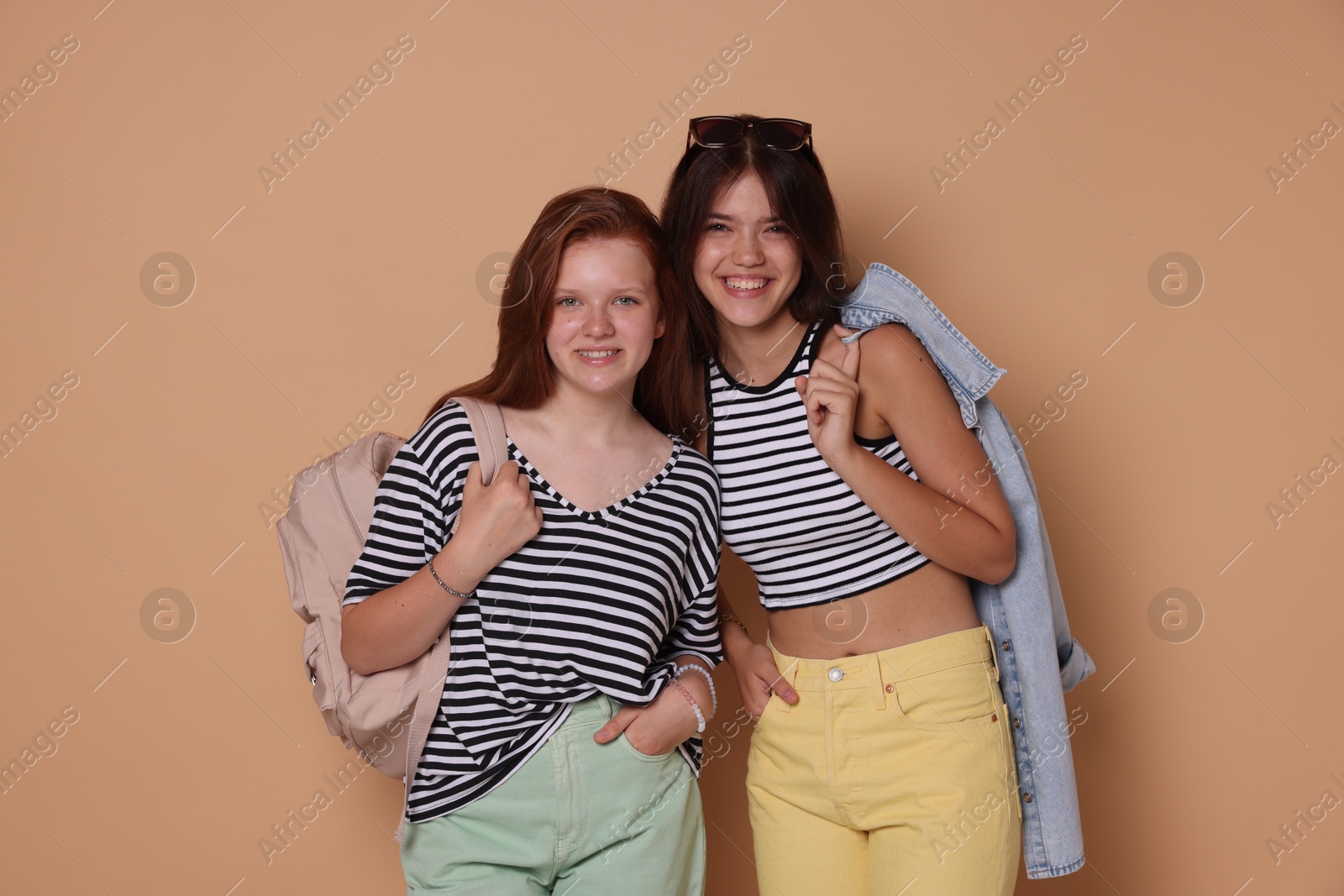 Photo of Happy teenage girls posing on beige background