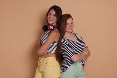 Photo of Happy teenage girls posing on beige background