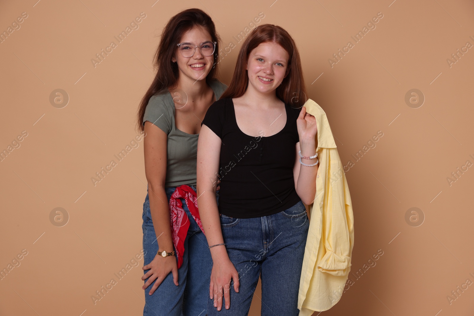 Photo of Happy teenage girls posing on beige background