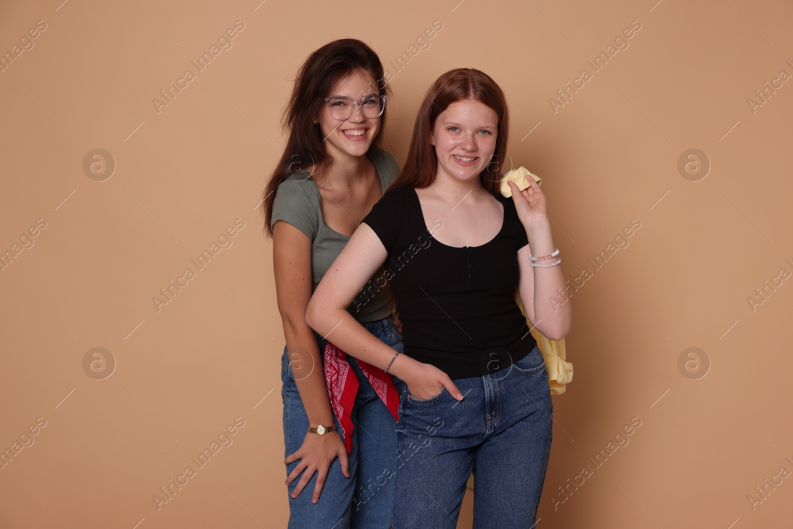 Photo of Happy teenage girls posing on beige background