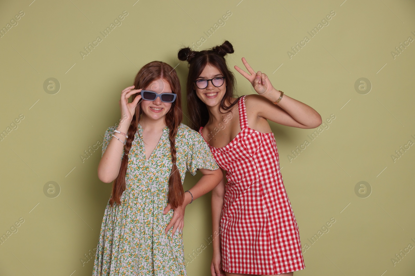 Photo of Happy teenage girls posing on green background