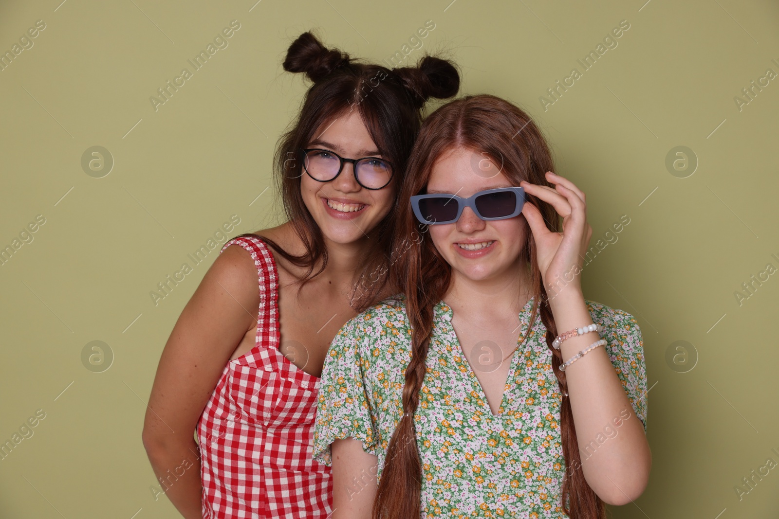 Photo of Happy teenage girls posing on green background