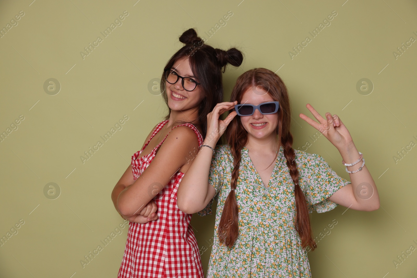 Photo of Happy teenage girls posing on green background. Space for text