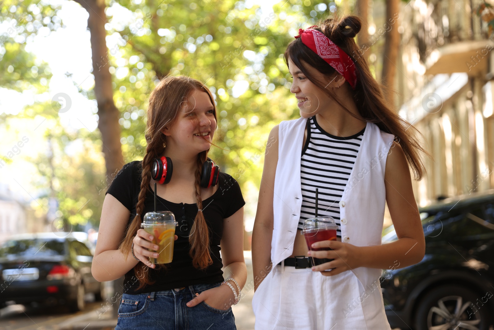 Photo of Happy teenage friends walking on city street