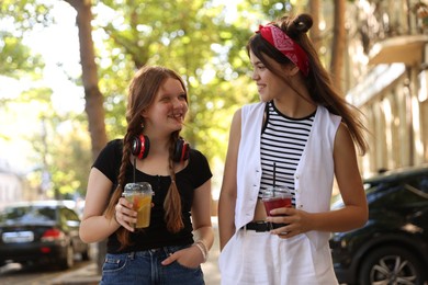 Photo of Happy teenage friends walking on city street