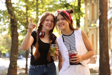 Happy teenage friends walking on city street