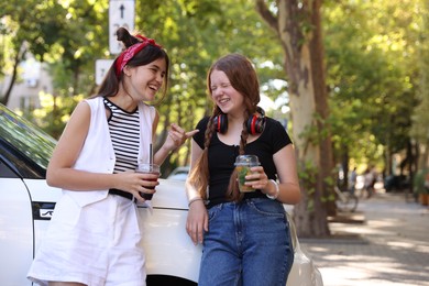 Happy teenage friends chatting on city street