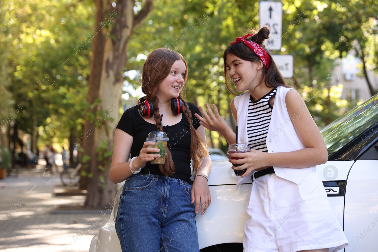 Photo of Happy teenage friends chatting on city street