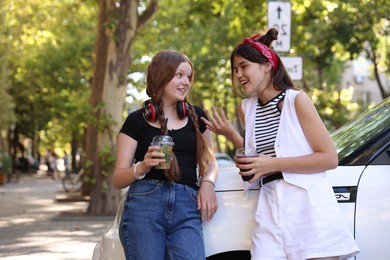 Happy teenage friends chatting on city street