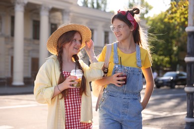 Happy teenage friends walking on city street