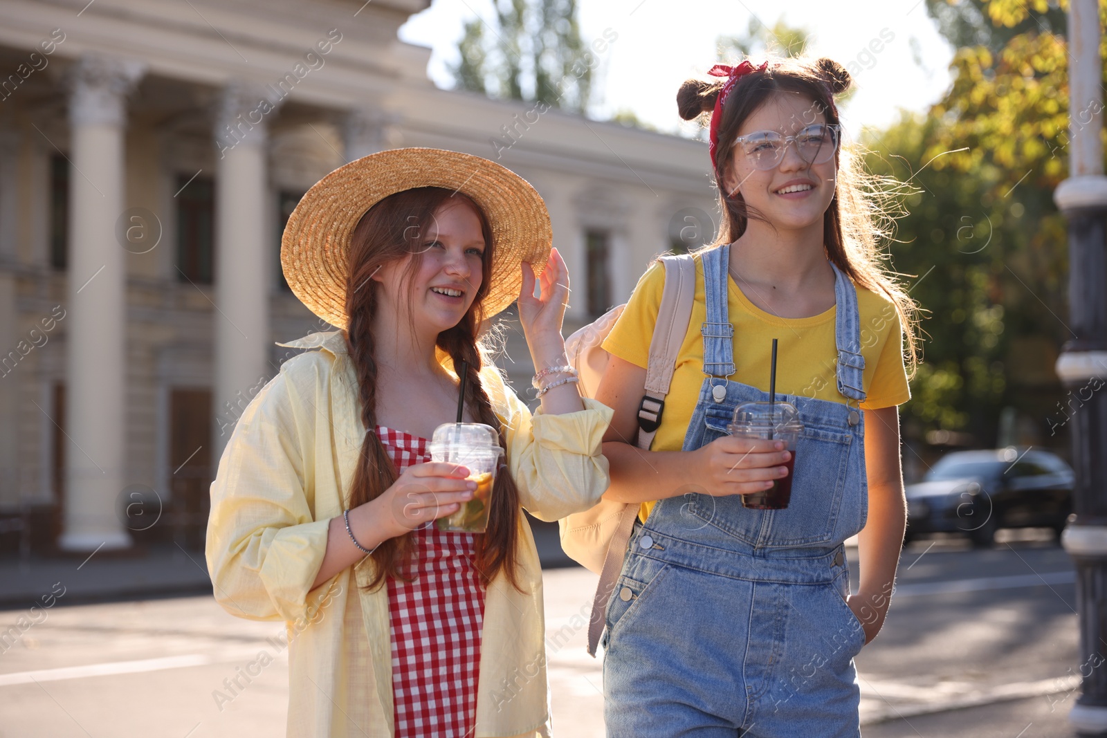 Photo of Happy teenage friends walking on city street