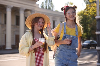 Photo of Happy teenage friends walking on city street