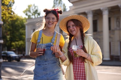 Photo of Happy teenage friends walking on city street