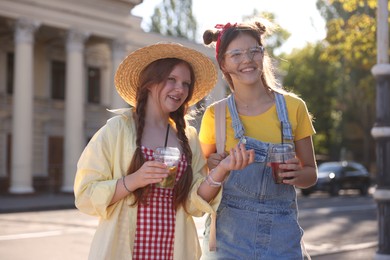 Happy teenage friends walking on city street