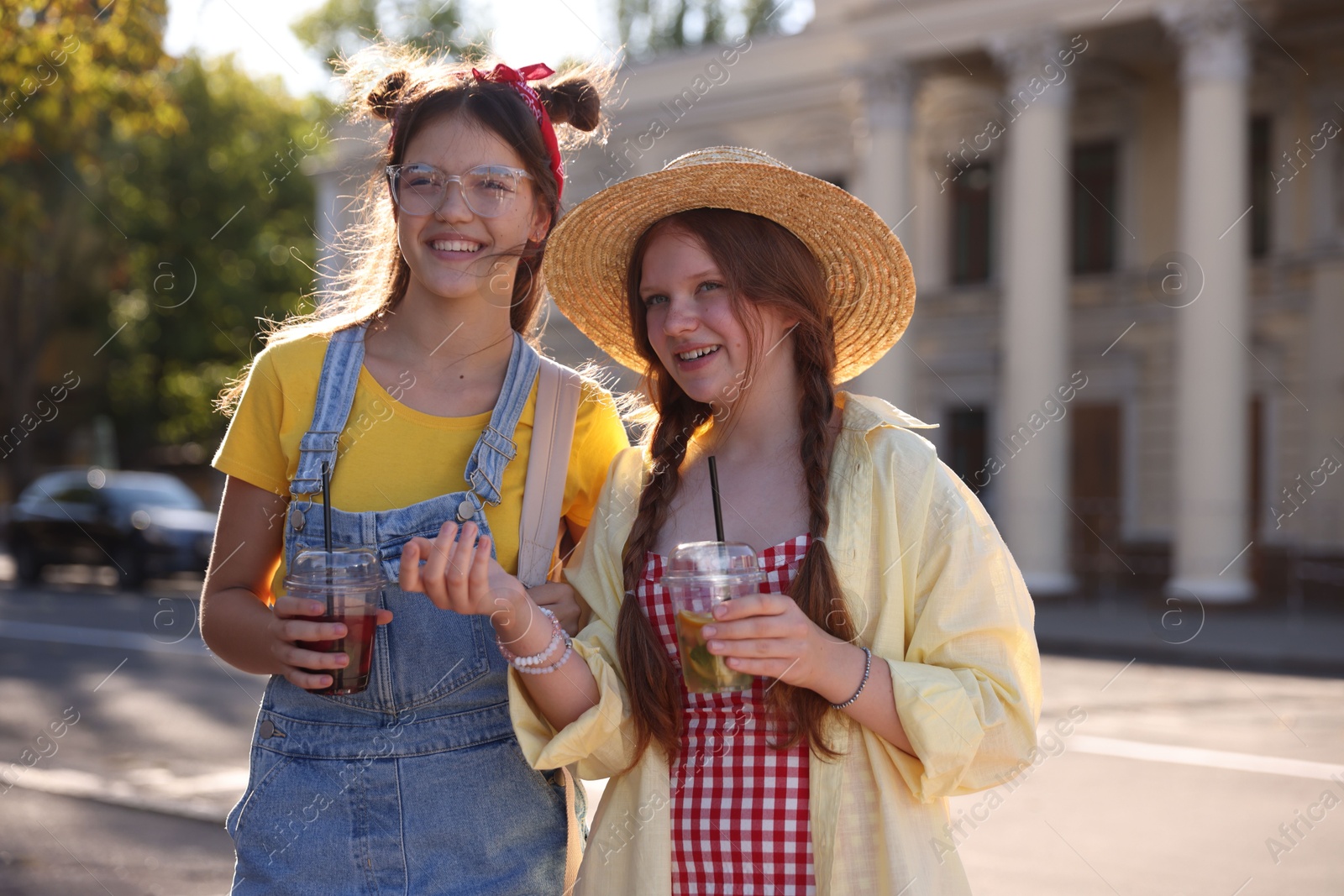 Photo of Happy teenage friends walking on city street