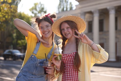 Happy teenage friends posing on city street