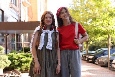 Happy teenage friends walking on city street