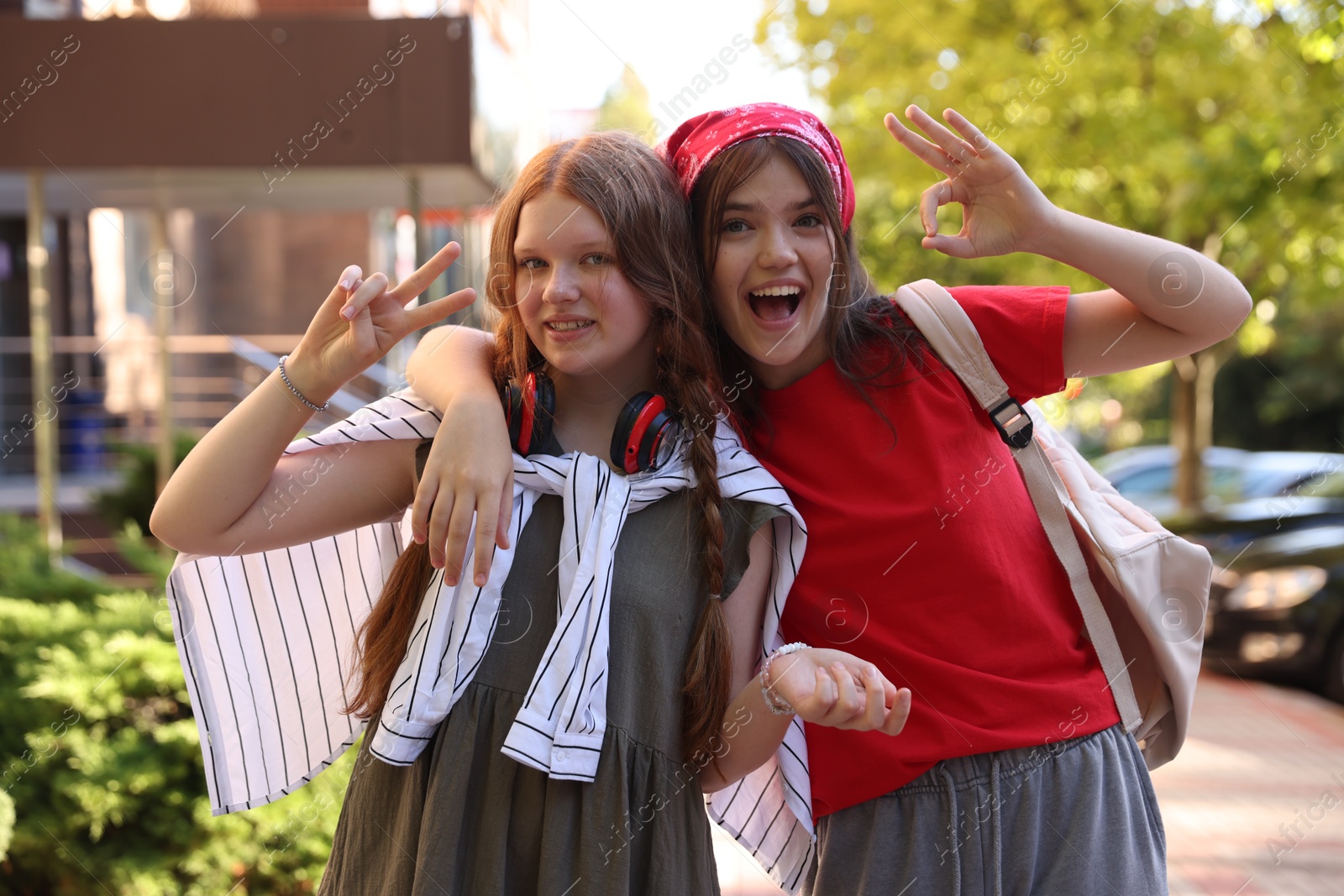 Photo of Happy teenage friends posing on city street