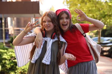 Happy teenage friends posing on city street